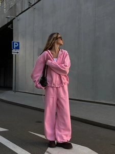 Detalle de conjunto informal rosa de dos piezas con sudadera con capucha y pantalón ancho