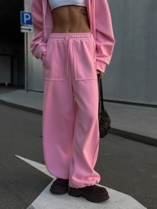 Detalle de sudadera corta rosa y pantalón ancho de chándal con bolsillos grandes
