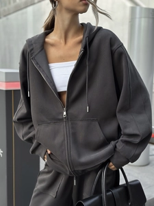 Detalle de la sudadera con capucha gris marengo y pantalones anchos de chándal