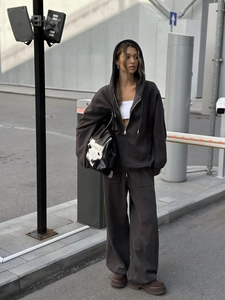 Detalle de sudadera oversize marrón chocolate con cremallera y pantalón ancho a juego