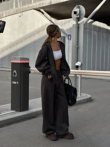Detalle de conjunto chándal marrón oscuro con capucha y pantalón ancho estilo urbano