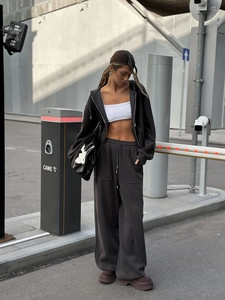 Detalle de conjunto de sudadera con capucha marrón oscuro y pantalones anchos de talle alto