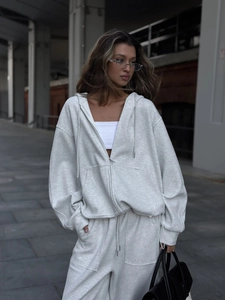 Detalle de conjunto gris claro con sudadera con capucha y pantalón de chándal ancho