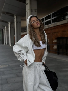 Detalle de sudadera gris oversize con cremallera metálica y pantalones deportivos