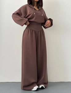 Détail de la couture en V à la taille sur le pantalon de jogging large marron