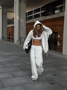 Detalle de conjunto gris claro con sudadera de cremallera y pantalón ancho de calle