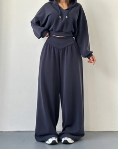 Détail d'un sweat à capuche court bleu marine et d'un pantalon de détente à taille en V