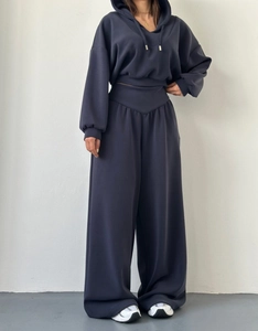 Détail du pantalon large taille haute avec taille en V et cordon de serrage en métal