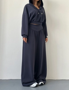 Détail du pantalon large à taille haute avec une ceinture croisée en V unique et élégante