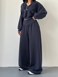 Détail d'un ensemble bleu marine avec sweat à capuche, taille en V et pantalon large