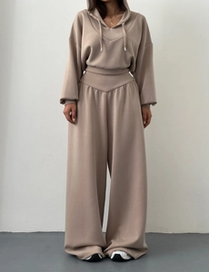 Détail du tissu du sweat à capuche et du pantalon large à taille haute en beige