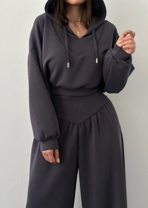 Détail d'un ensemble de détente gris foncé avec sweat à capuche et pantalon large