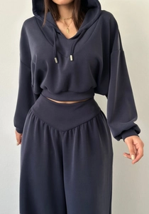 Détail du sweat à capuche court bleu-gris et du pantalon large à taille haute ajustée