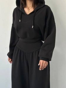 Détail du sweat à capuche noir avec cordons à embouts métalliques et pantalon large