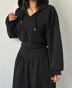 Détail du sweat à capuche noir avec cordon et pantalon assorti à taille haute et jambe large