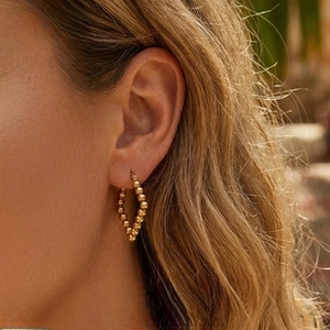 Close-up of elegant gold beaded ribbon tassel earrings with 18K gold plated finish