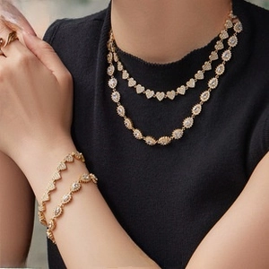 Detail of 18k gold plated stainless steel jewelry set with heart-shaped white zircon stones