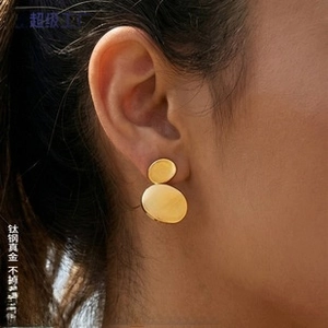 Close-up of gold-plated titanium steel double disc earrings worn by a model