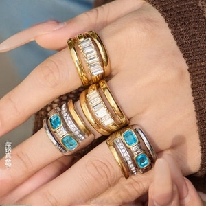 Macro detail of gold plated titanium steel rings with light blue rectangular zircon stones