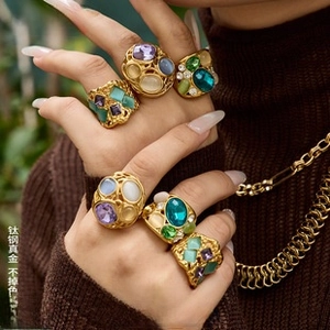 Close-up of vintage gold-plated titanium rings set with colorful gemstones on a model