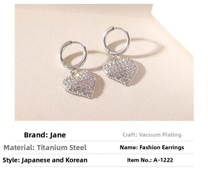 Detailed view of silver heart earrings with micro-paved rhinestones and hoop closures