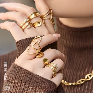 Detail showing stacked gold plated titanium steel rings and chain on model hand