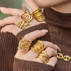 Macro shot of 18K gold plated chunky stainless steel rings on finger with textured finish