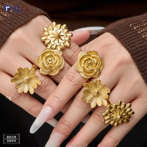 Detailed view of rose and sunflower gold-plated rings worn on hand for jewelry styling