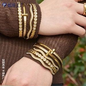 Detailed view of layered 18K gold plated titanium steel bangles with sparkling zircon accents