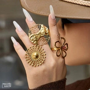 Detail of 18K gold-plated titanium steel rings featuring solar and floral patterns