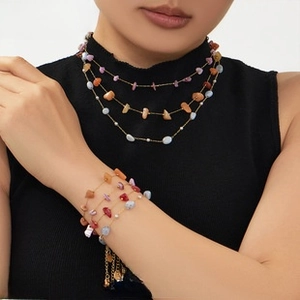 Close-up of bohemian multilayer necklace and bracelet with colorful natural crushed stones