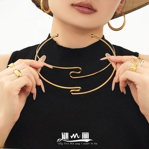 Polished gold stainless steel choker and matching earrings worn by a model in a stylish look