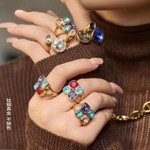 Detailed view of stacked 18K gold-plated titanium steel rings with colorful gemstones