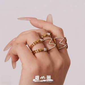 Detailed view of stacked gold plated rings with leaf design and sparkling zircon stones