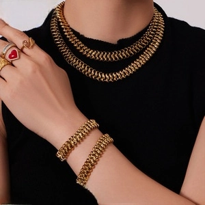 Close-up of vintage gold woven chain necklace and bracelet set with retro textures