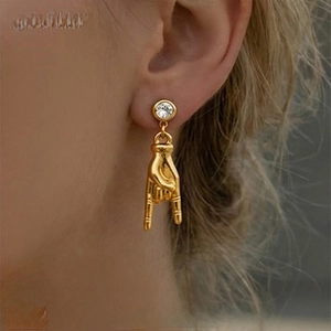 Detail of 18K gold plated gesture stud earring with crystal on model profile view
