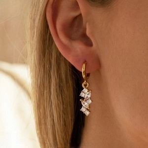 Detailed shot of gold hoop earrings with clustered clear marquise crystals on person