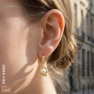 Close-up of vintage French pearl drop earrings with textured 18K gold plated titanium hooks