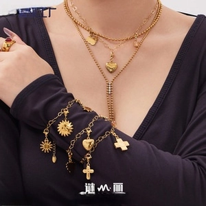 Close-up of gold layered jewelry set featuring necklaces and bracelets on model