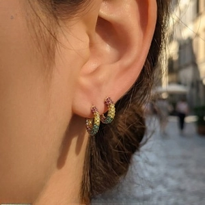 Detail of colorful rainbow pavé crystals on gold-plated round hoop earrings for women