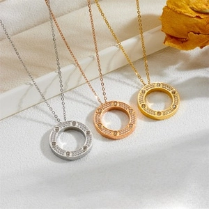 Detailed macro of crystal-encrusted ring pendants in silver, gold, and rose gold finishes