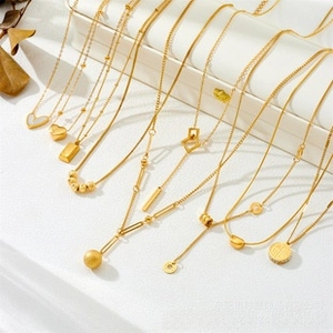 Detailed close-up of various gold necklaces with heart and geometric pendants