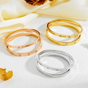 Detailed view of six screw-style bangle bracelets with crystals in gold and silver tones