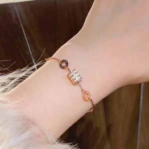 Macro detail of rose gold titanium bracelet with cubic zirconia block and engraved rings