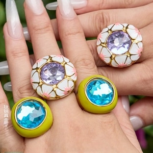Close-up of gold-plated titanium rings with leopard print enamel and vibrant gemstones
