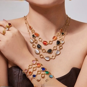 Detail of bohemian gold plated jewelry set with colorful opal stones on model