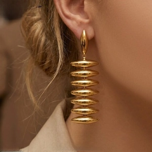 Macro detail of layered gold-plated C-shape earrings with a high-gloss finish on model