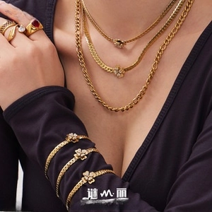 Close-up of gold plated stainless steel necklaces and bracelets with clover charms