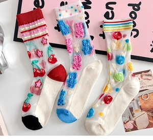 Macro shot of ultra-thin sheer socks featuring cartoon bear and cherry patterns