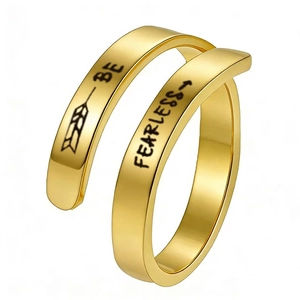 Detail of gold open ring featuring Be Fearless engraved text and arrow design